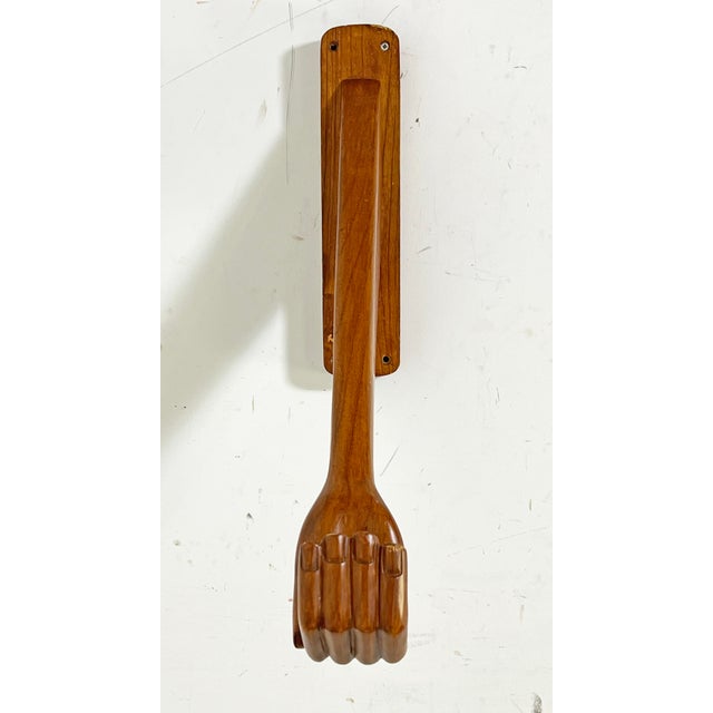 Wall mounted hand carved wooden hat or coat hook in the form of a human arm, reminiscent of Pedro Friedeberg's hand themed...