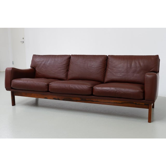 Danish Modern Leather and Rosewood Sofa by Eran, 1960s. Fantastic Scandinavian Mid-Century Modern large three-seater sofa...