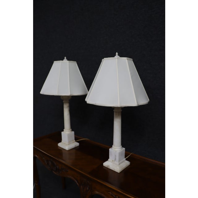 Elegant pair of Neoclassical-style table lamps crafted in solid white marble with fluted column shafts and stepped plinth...