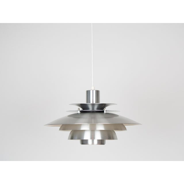 This lamp was designed by Danish designer Kurt Wiborg and manufactured by Jeka. The lamp's form is based on the principle...