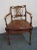 Regency style arm chair , carved walnut frame with floral accents , lattice style back , cane seat , loose cushion