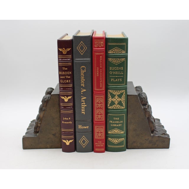 Pair of bronze plated bookends, circa 1900, likely American. Bronze plate on metal. Each featuring a relief of Putti...