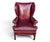 This Baker wingback chair features rich burgundy leather upholstery, a tall back, and classic rolled arms. Brass nailhead...