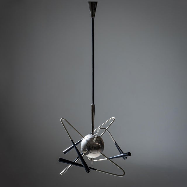 Futuristic five-arm Space-Age chandelier featuring a central aluminum sphere and elegantly curved arms with black sockets....