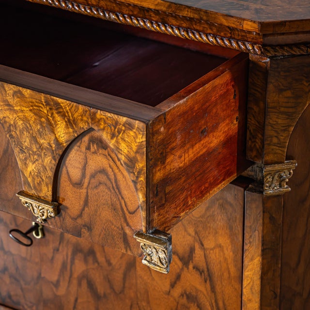 Elegant pair of commodes crafted from walnut and burl veneer, featuring chamfered corners, a straight profiled base, and...