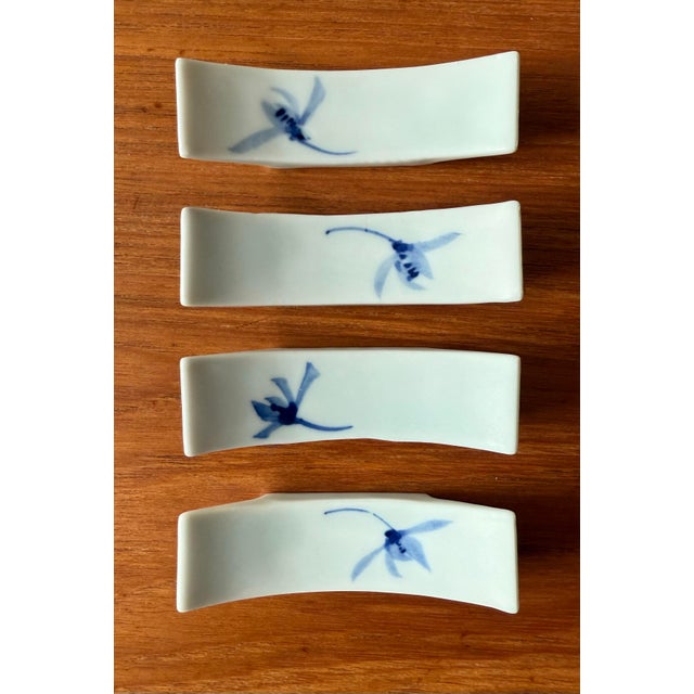 Set of 4 vintage white porcelain Hashioki or chopstick rets with a blue flower design. Rests are made in a curved "boat"...