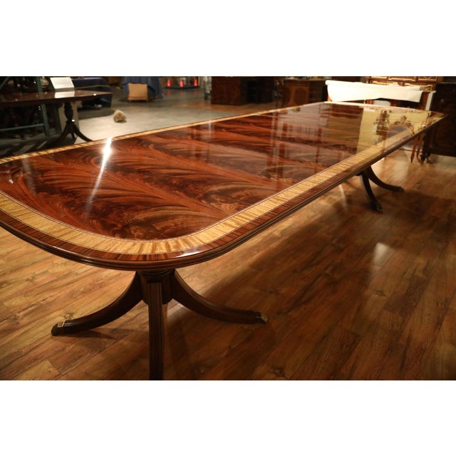 Mahogany dining table with three leaves. This 12-foot dining table seats up to 14 people when fully extended. It features...
