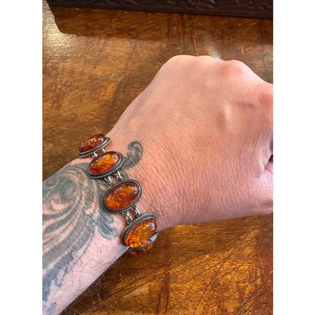 Gorgeous bracelet with ten oval amber stones set in sterling silver with oxidized rope trim around each stone. Wonderful...