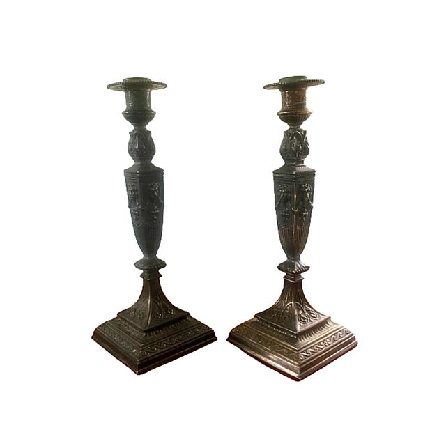 A pair of Grand Tour Neoclassical style bronze candlesticks with lion heads and swags. The candle cups are removable.