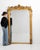 Here is a mirror, its gold gilt ornate frame with figural crest the first thing to catch the eye. It was made in France...