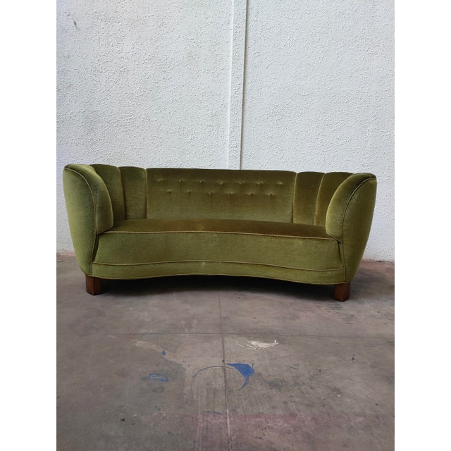 : Banana curved sofa with an elegant design and green velvet upholstery, Denmark, 1980s. – Wooden legs. – Button-tufted...