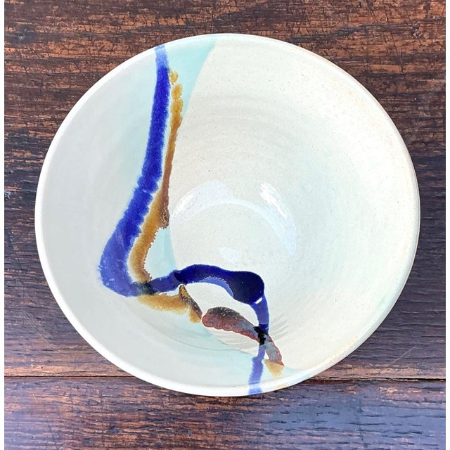 This handcrafted abstract glazed ceramic bowl is a striking example of contemporary studio pottery, blending expressive...