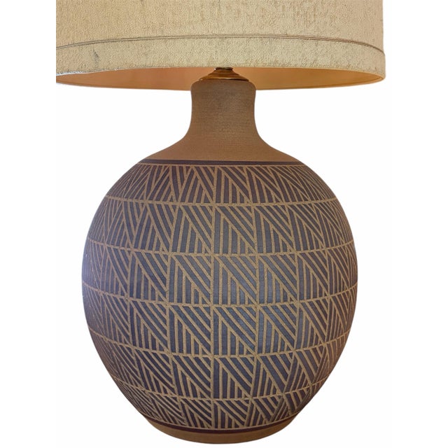 This Mid-Century Modern table lamp features a hand-crafted bulbous studio pottery base rendered in a warm, earthy brown...