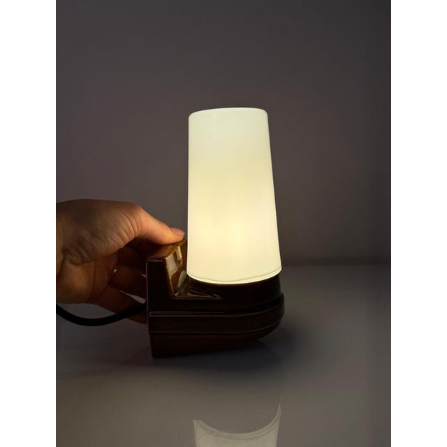 The Model 6080 wall lamp in brown by Sigvard Bernadotte for Ifö Electric is a classic of Swedish design. The angular base...