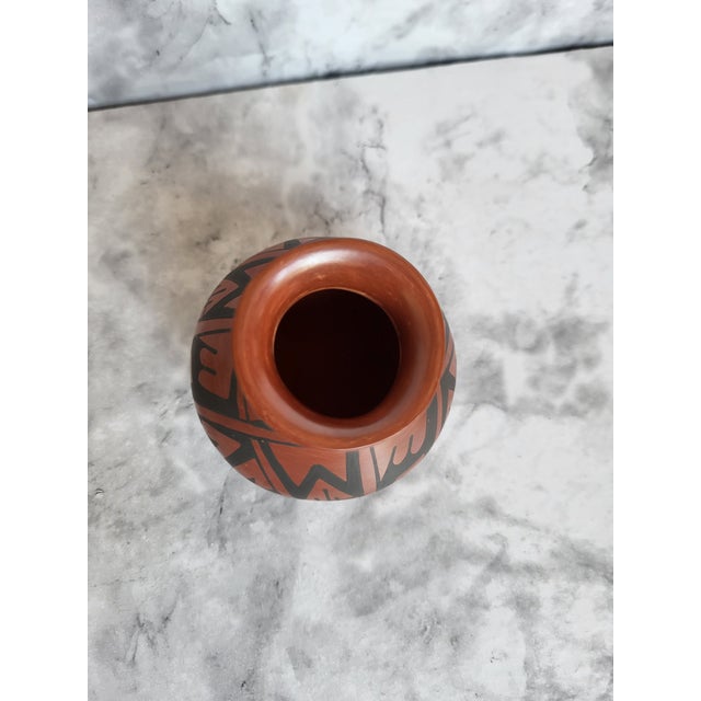 Beautiful signed miniature terracotta pot. It is handmade and carved geometric designs. Signed by Walter Lopez on the bottom