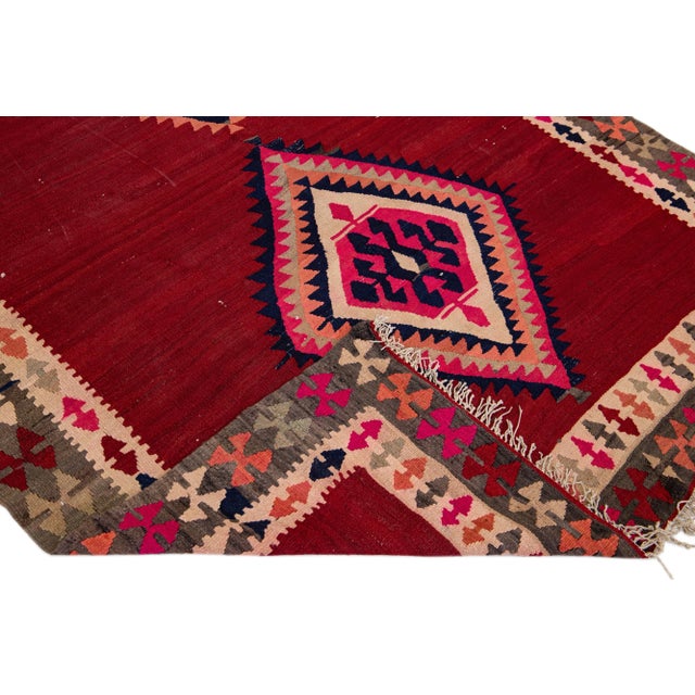 Beautiful vintage Turkish Kilim hand-knotted wool rug with a tan field. This piece has a brown frame and multicolor...