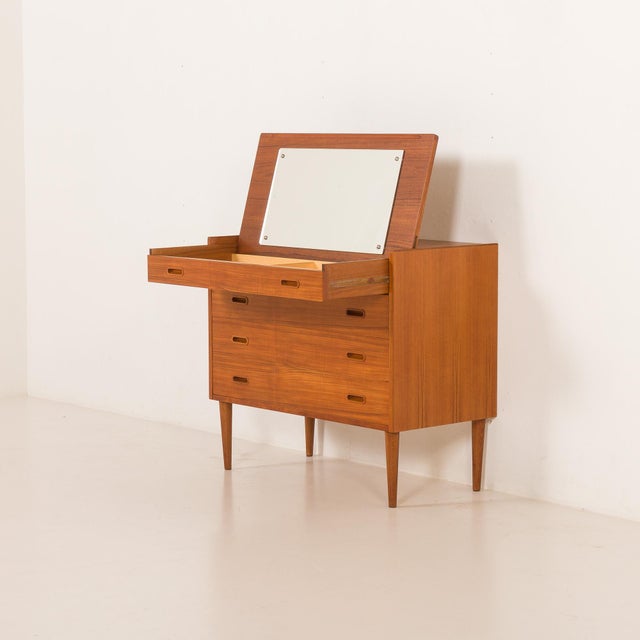 This charming Danish mid-century dresser features a hidden vanity and it was made some time in the 1960s. It seamlessly...