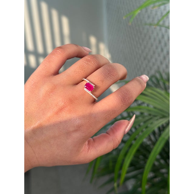 This bypass ring features a 1.25 carat emerald-cut ruby, set in 14K yellow gold. The vibrant ruby measuring 7 x 5 mm. The...