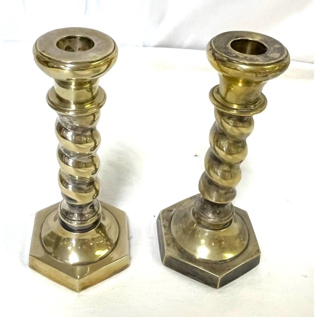 1970's pair of barley twist candlesticks. They are made of heavy brass plated metal. There's a sticker on the bottom which...