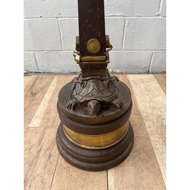 A distinctive vintage pedestal side table featuring a sculptural turtle-form base supporting an architectural obelisk-...