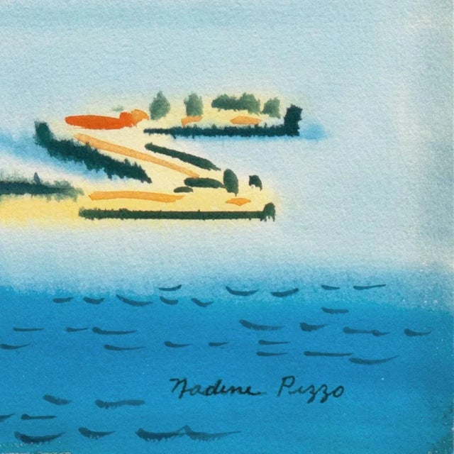 A vibrant coastal landscape showing a view of a jetty extending into the cove of a beachside town with a view to mountains...