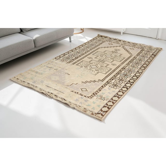 This is a vintage Turkish Oushak rug from the Mid 20th Century. The piece was hand-knotted.