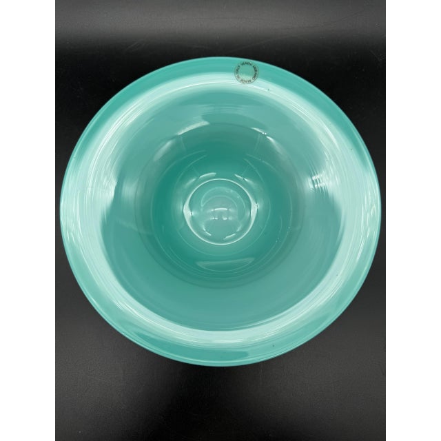 Blown glass bowl by Venini. The material is opaline glass. The color is aqua blue. It has the original circular mark to...