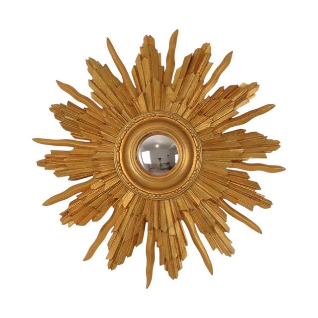 Vintage gold-tone sunburst mirror featuring convex glass; crafted from wood in France, circa mid-20th century. Highly...
