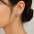 14K white gold earrings featuring 96 natural pink sapphires (1.99 ct) and 62 brilliant diamonds (0.50 ct) in a buckle-...