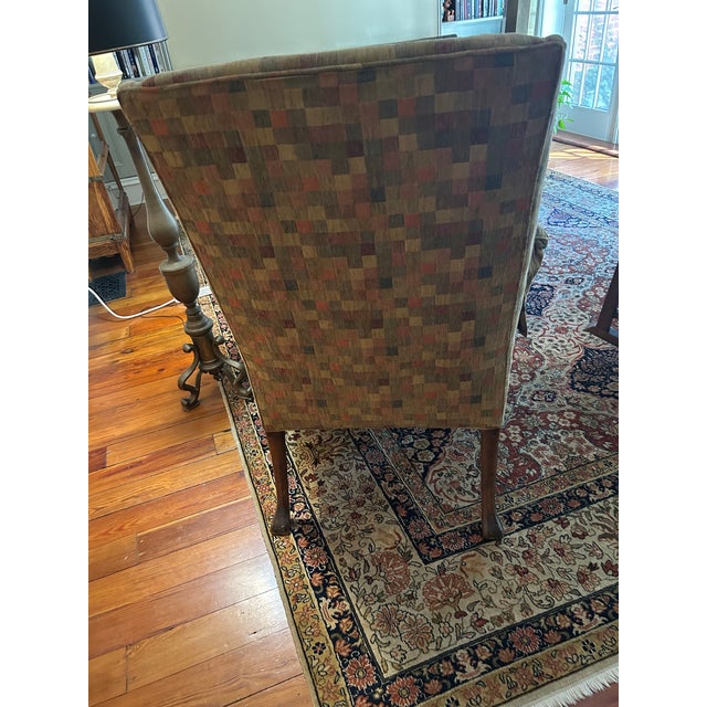 Large club chair, in check upholstery. Subtle gold and orange coloring. You'll get two large, fringed pillows and an...