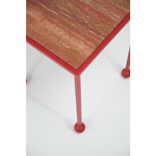 A side table that combines the timeless rigor of Red travertine with the vibrancy of bold color. The travertine top meets...