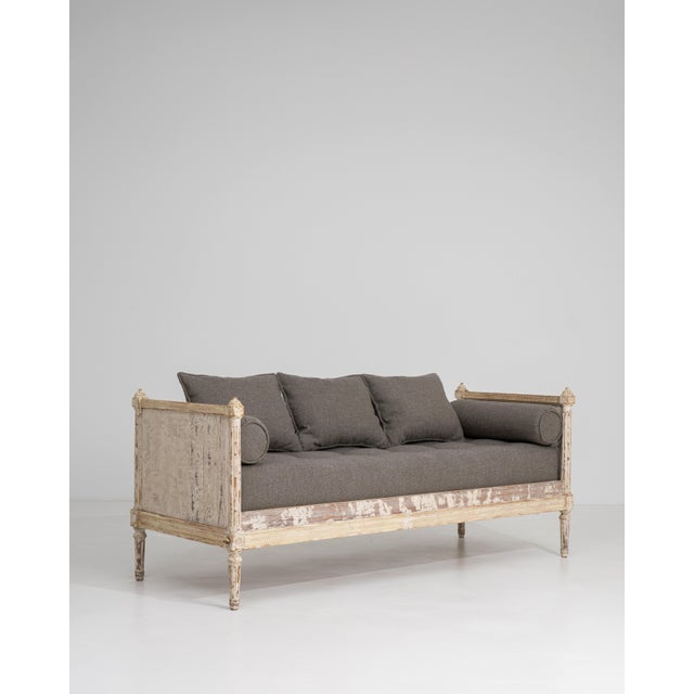 An elegant Louis XVI style daybed featuring a white patinated finish that enhances its decorative appeal. The structured,...