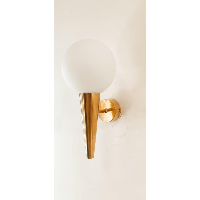 Brass Wall Light with White Sphere, in Very Good conditions. Designed 1970 to 1979 Up to 250V (Europe/UK Standard).The...