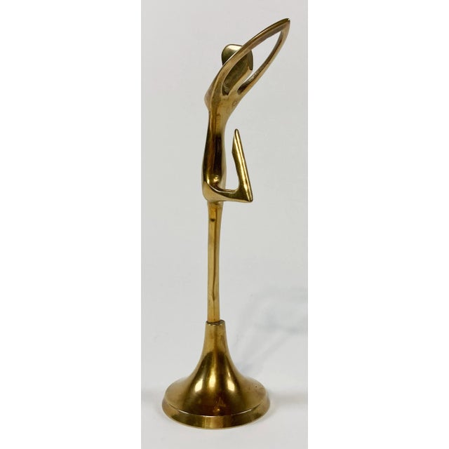 Vintage brass ballerina or dancer figure in arched pose on brass pedestal stand. Lovely patina.