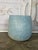 A beautifully understated terracotta planter featuring a clean, rounded silhouette and a softly weathered blue-gray...