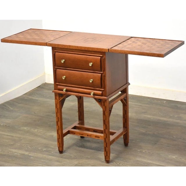 A mahogany antique game table with alternating woods to create a chess board on both drop leaves. Polished brass knobs....