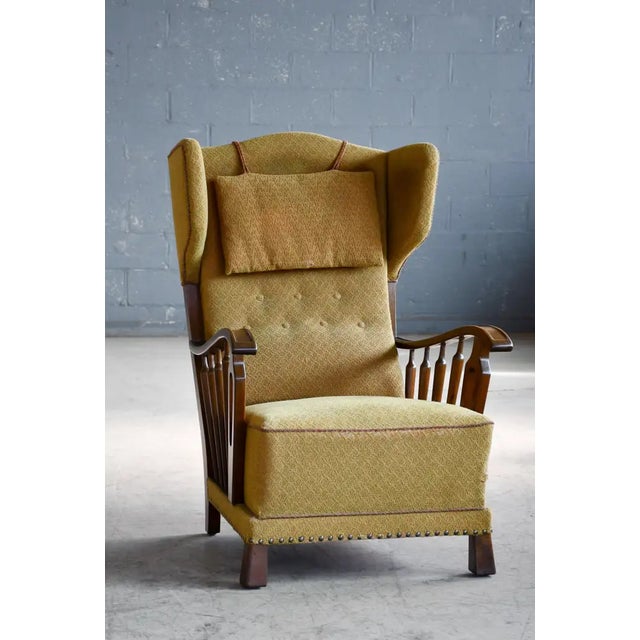 Beautiful and very unique Danish 1940s wingback chair with nicely carved armrest in stained beechwood. Very elegant with...