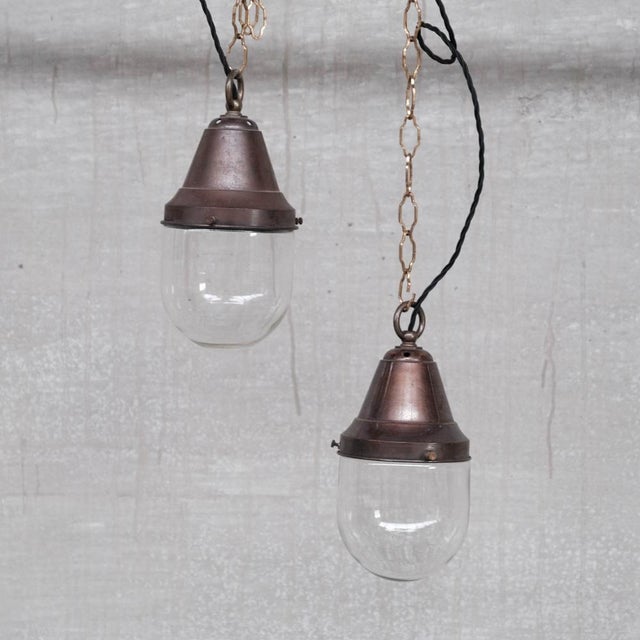 A pair of naturally patinated brass and glass pendant lights. France, c1930s. Industrial style but decidedly more flexible...