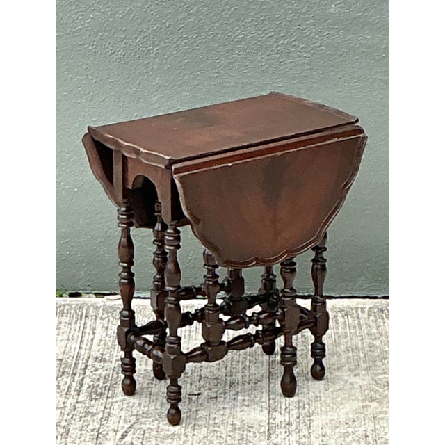 This charming vintage gate-leg side table beautifully captures the timeless appeal of English Jacobean design. Crafted...