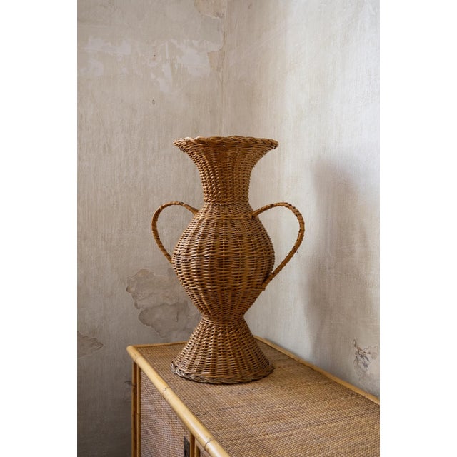 Decorative amphora entirely crafted from woven wicker, featuring a rounded central body, flared neck and two large side...