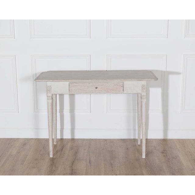 A Swedish Gustavian side table from the 19th century, combining graceful proportions with the understated elegance of...