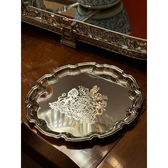 A set of 12 silver plate chargers or service plates, in the Georgian taste, with scalloped edge, the centers engraved with...
