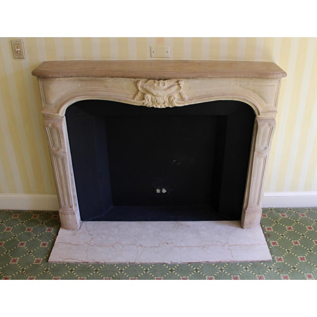 Louis XV carved limestone mantel with a replacement hearth. This mantel was imported from Europe and installed in the...