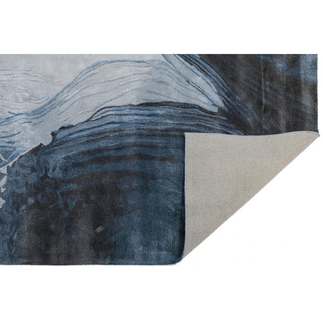 Elevate your interior with this stunning modern hand-tufted rug, featuring a dynamic abstract design inspired by natural...