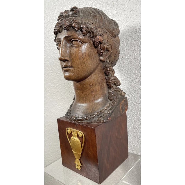 A fine late 18th century French carved wood head of a pretty young woman in the Greco-Roman taste. Grecian fashion gained...