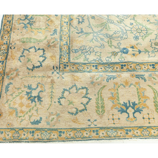 An early 20th century Persian Tabriz antique rug, the camel field with an overall design of enlarged whimsical cloudbands...