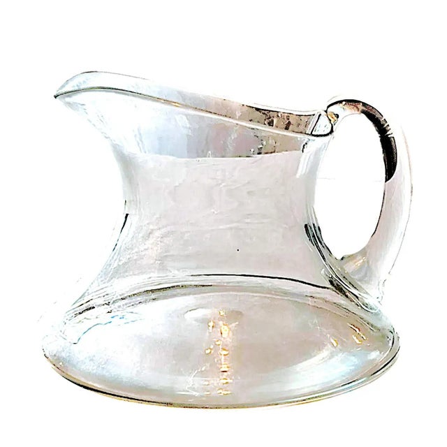 This is a 1970s modern minimalist hand blown clear glass pitcher with a ships wine decanter shape in the style of Orrefors...