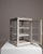 Here is a vitrine, its white painted wood, glass doors, small display case the first thing to catch the eye. The piece...