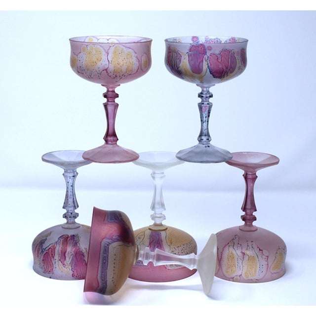 A 6 piece set of hand-blown, hand-etched glass champagne coupe or sherbet glasses that feature a pink and yellow mult-...