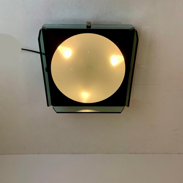 Italian wall and/or ceiling lamp made of a dark taupe enameled metal box with a spherical acrylic glass lampshade in the...